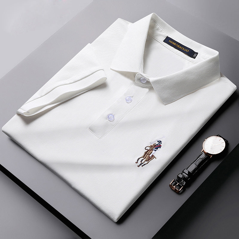 Close-up of fine embroidery on front of green cotton polo tee