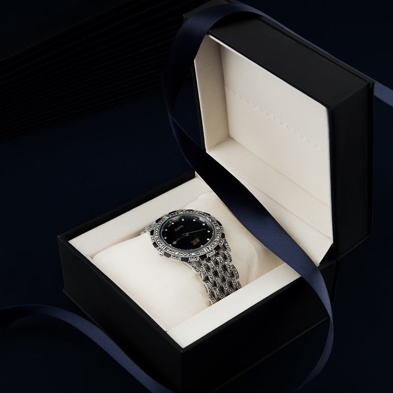 Black dial luxury quartz watch worn on the wrist, showcasing elegance and style.