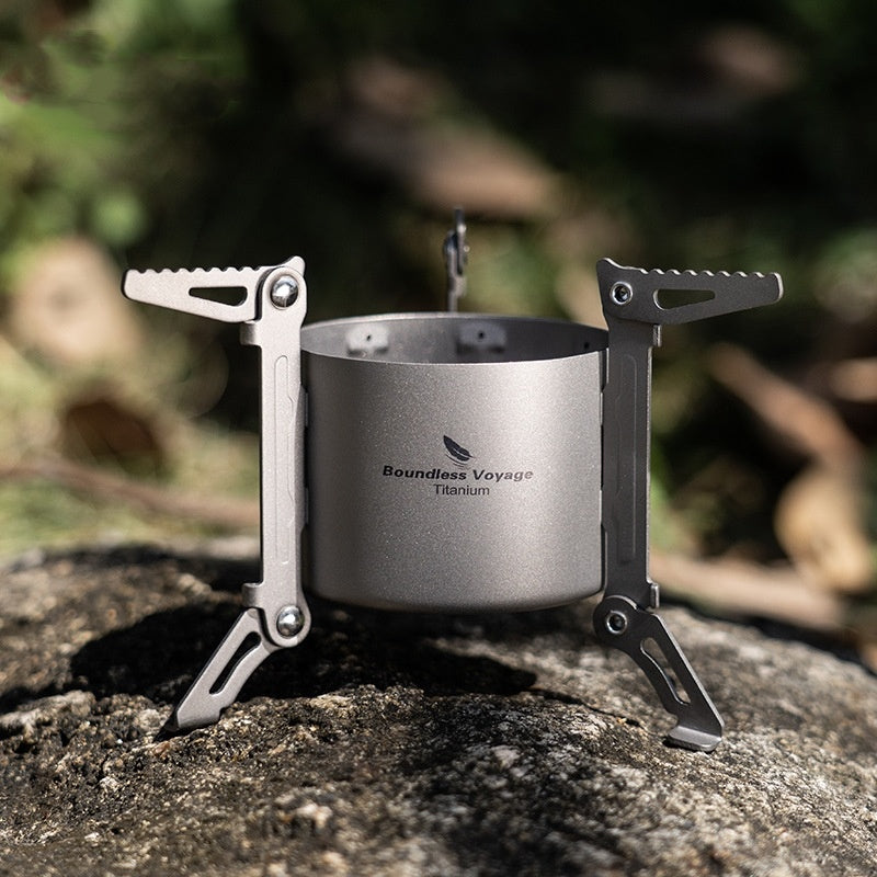 Titanium stove held in hand to show compact size