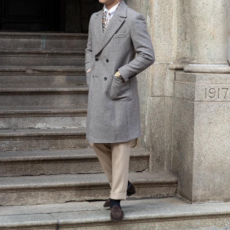 Grey wool coat displayed on a mannequin, emphasizing its refined lapel collar and tailored fit.