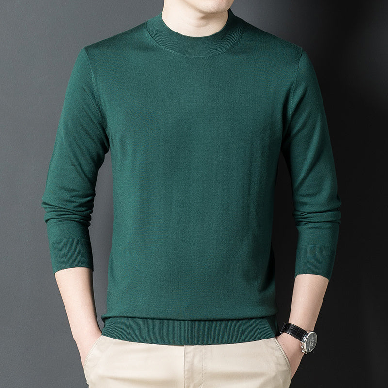 Stack of folded cashmere sweaters in black, camel, green, and blue
