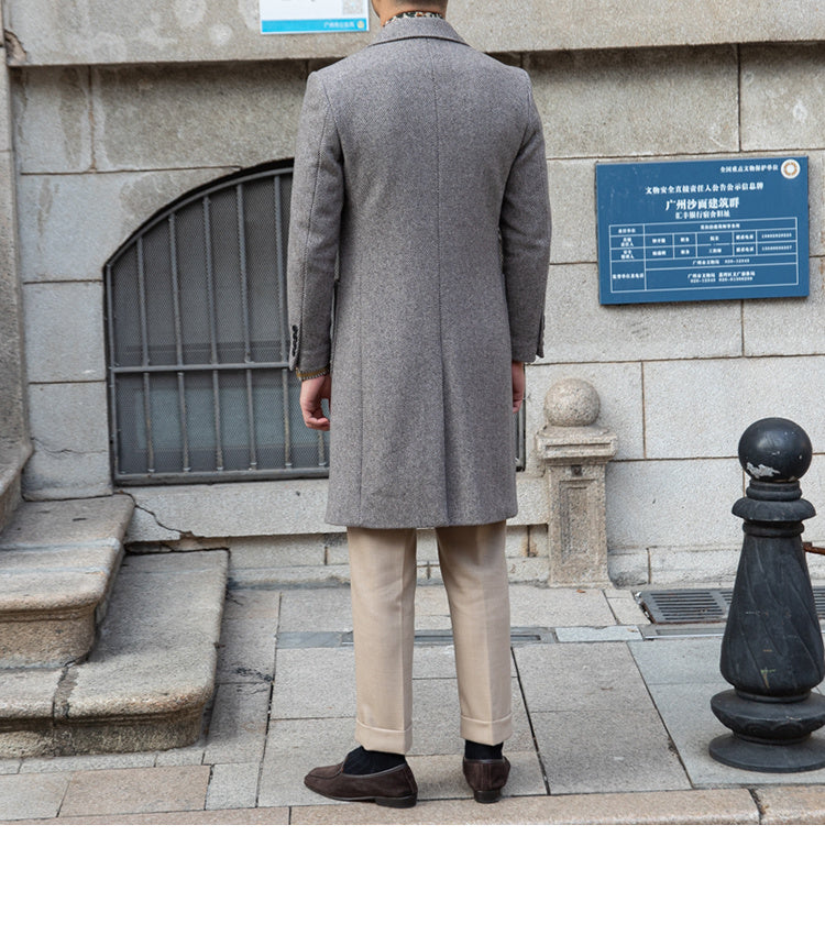 Grey wool coat flat-laid, showcasing its premium fabric blend and detailed stitching.