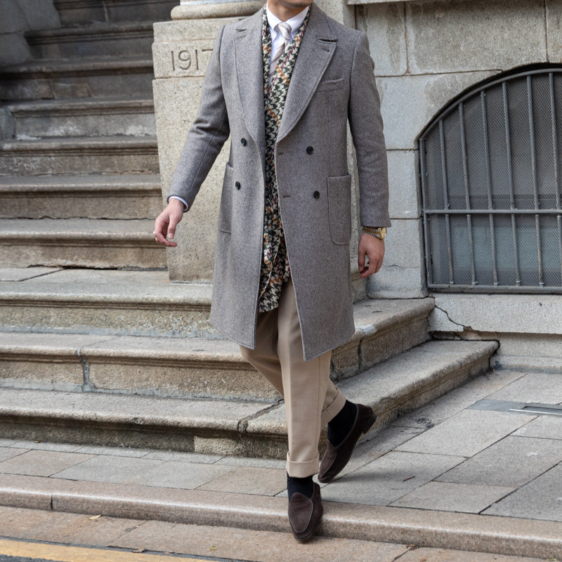 Close-up of a grey double-breasted wool coat showcasing the button closure and fine craftsmanship.