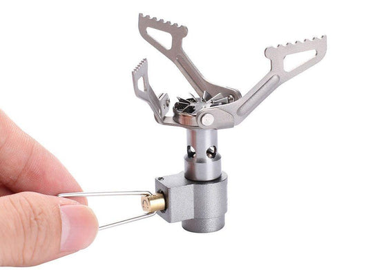 Compact titanium camping stove with high-speed rotary flame, perfect for outdoor cooking.