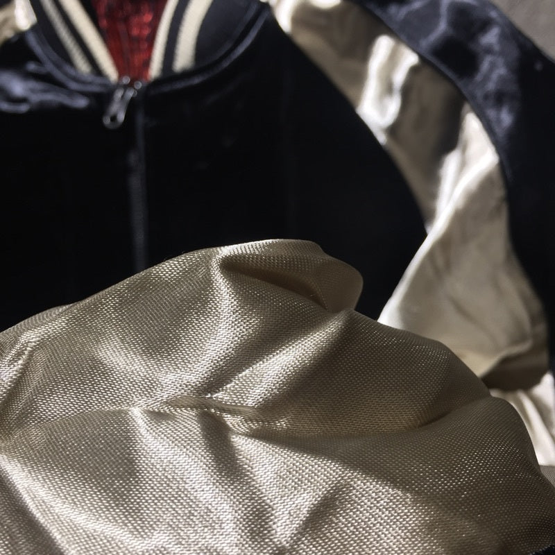 Man wearing embroidered satin jacket with dragon and tiger art