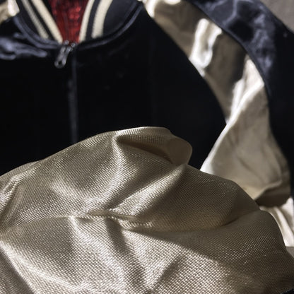 Man wearing embroidered satin jacket with dragon and tiger art