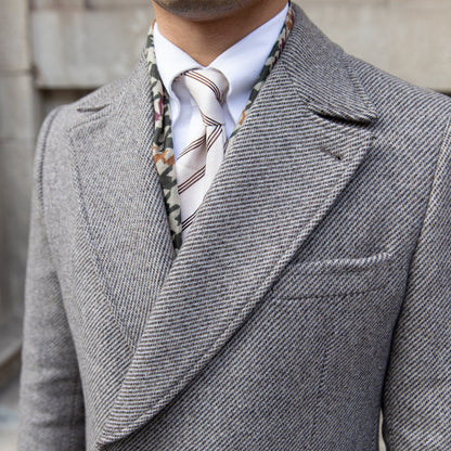 Grey wool coat styled with a focus on its double-breasted closure and elegant silhouette.