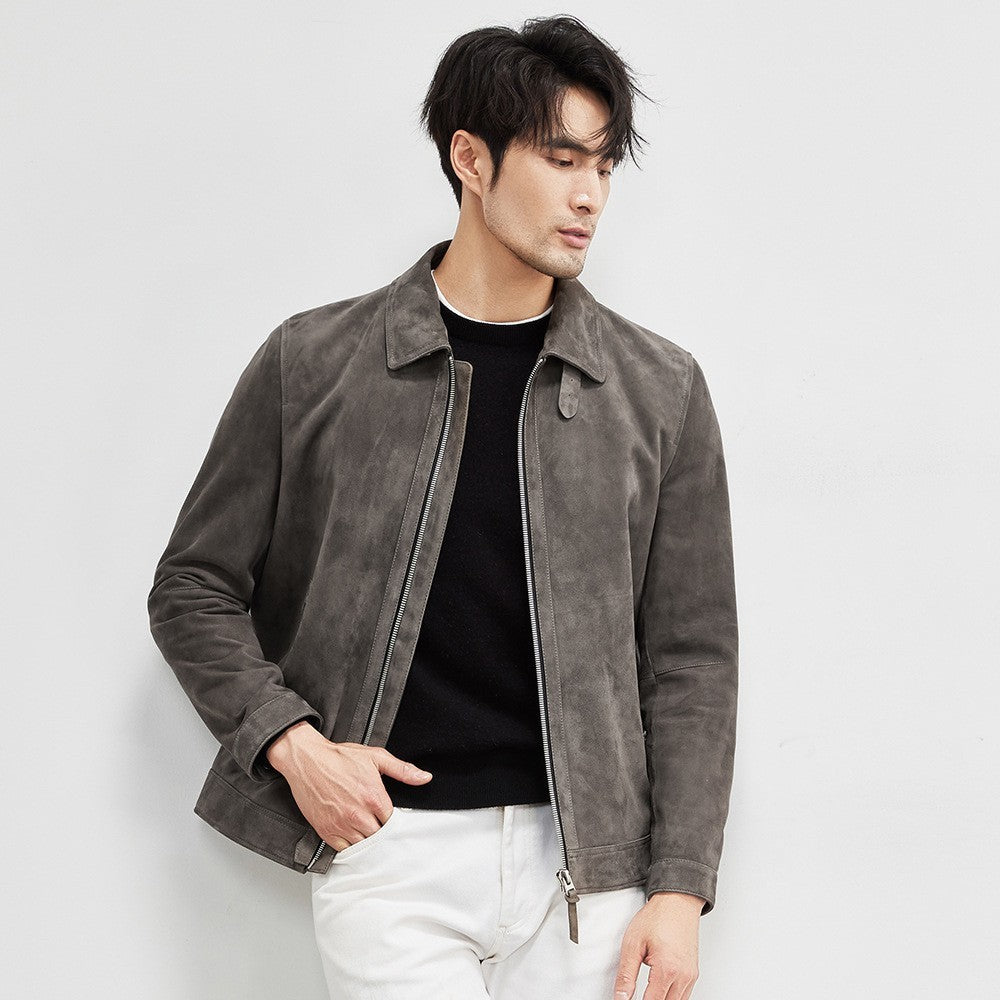 Man styled in suede leather jacket walking through urban setting