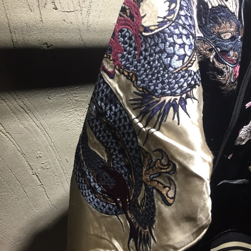 Man styled in dragon and tiger bomber jacket in urban setting
