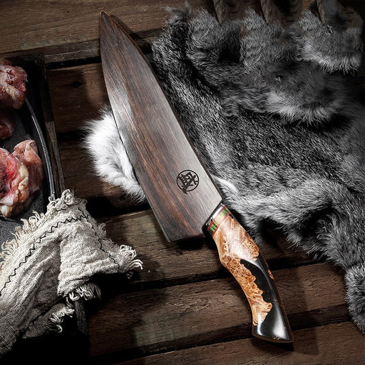 Damascus steel knife on a kitchen counter next to freshly skinned fur and butchered meat.