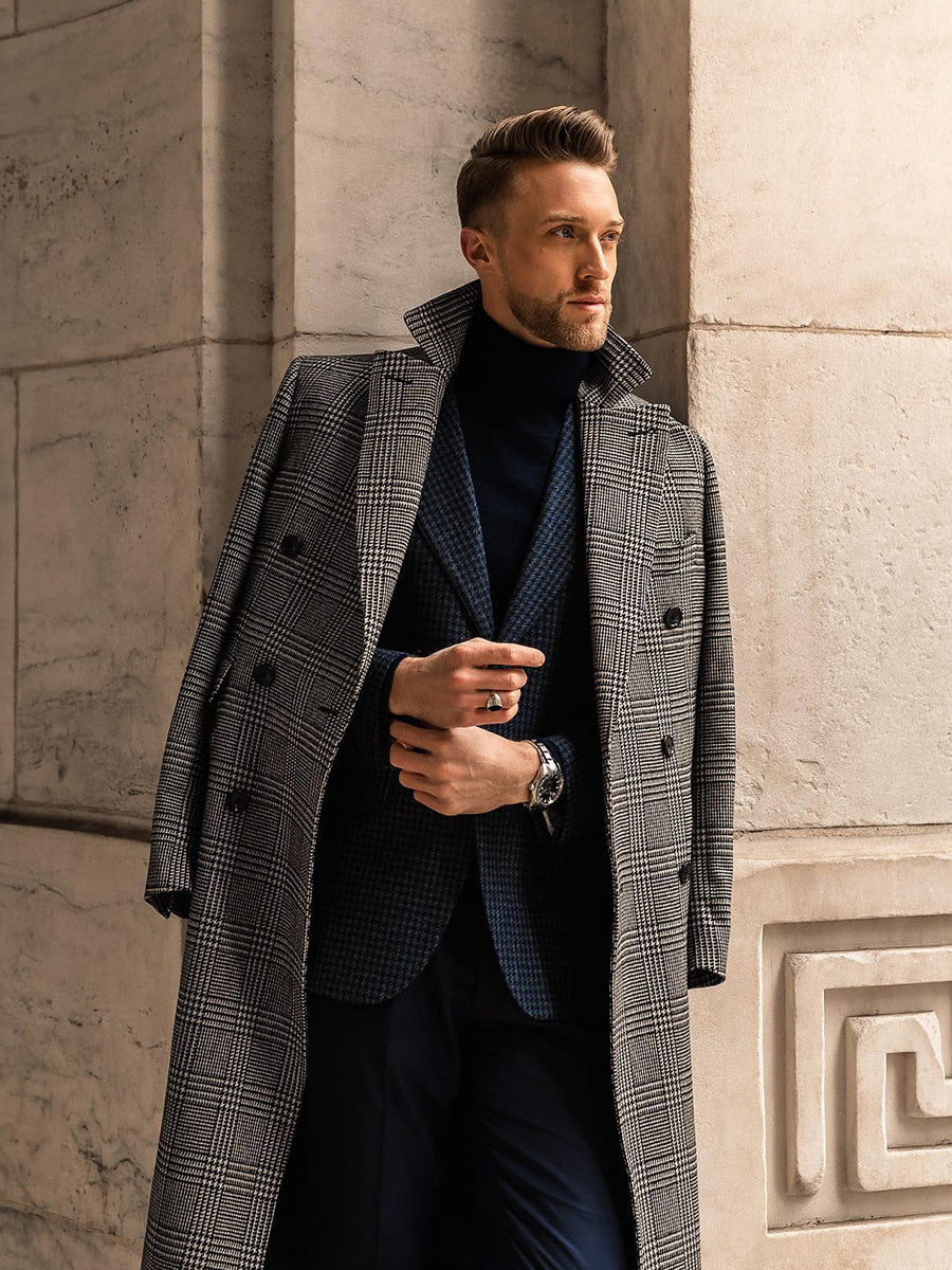 Full view of a modern man in a gray checkered overcoat carrying a briefcase, standing in front of a Roman-style courthouse or government building.