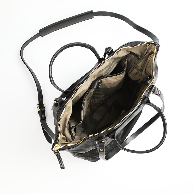 Open black leather tote bag viewed from above, revealing its spacious and organized interior.